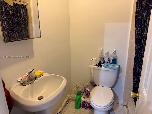 bathroom with tile patterned flooring, walk in shower, sink, and toilet