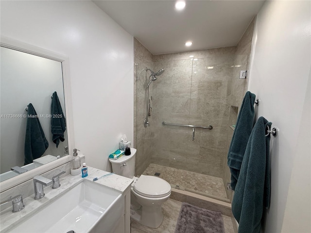 bathroom featuring vanity, toilet, and a shower with shower door