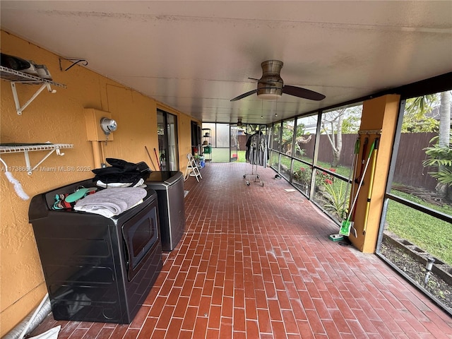 unfurnished sunroom with ceiling fan and washer / clothes dryer