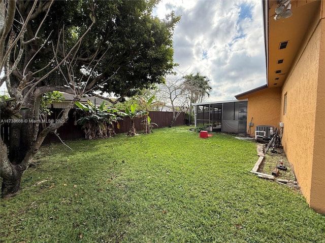 view of yard with central AC and a sunroom