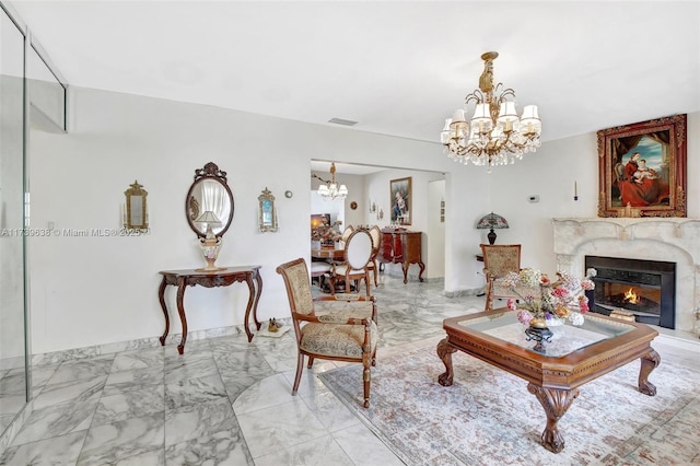 living room featuring marble finish floor, a notable chandelier, visible vents, and a premium fireplace