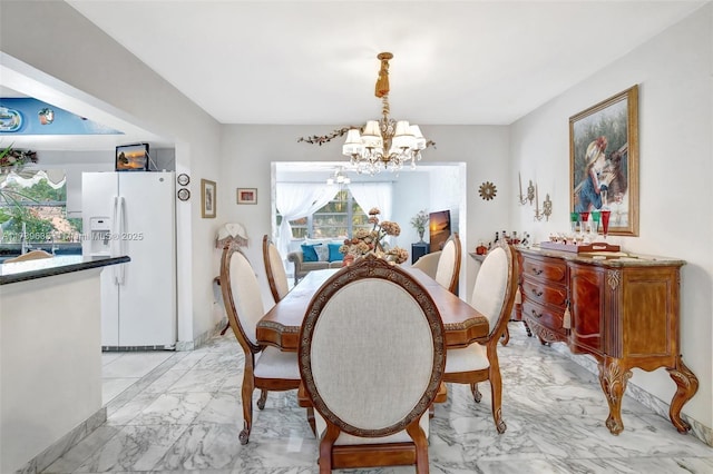 dining space featuring marble finish floor and a chandelier