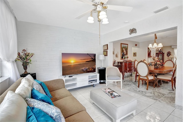 living room with brick wall and ceiling fan with notable chandelier