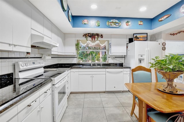 kitchen with sink, backsplash, white cabinets, light tile patterned floors, and white appliances