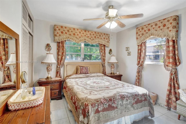 bedroom featuring ceiling fan, a closet, and light tile patterned floors