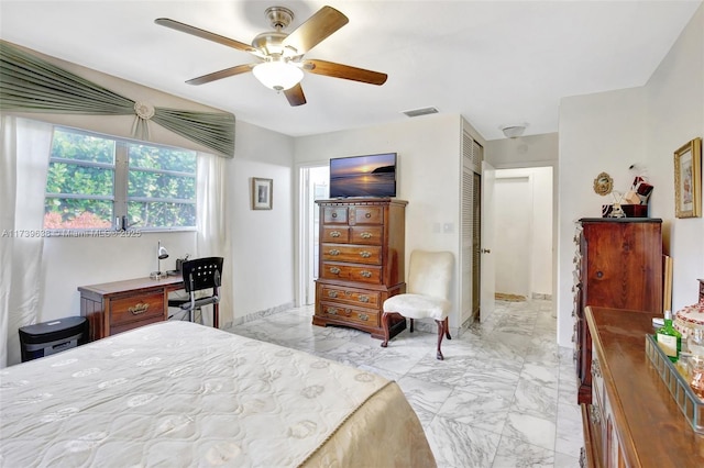 bedroom featuring visible vents, a ceiling fan, marble finish floor, and a closet