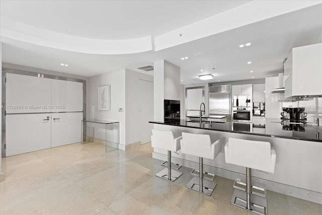 kitchen with sink, a kitchen breakfast bar, stainless steel appliances, white cabinets, and kitchen peninsula