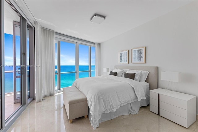 bedroom featuring expansive windows, a water view, and access to outside