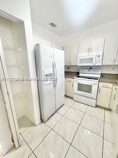 kitchen featuring light tile patterned floors and white appliances