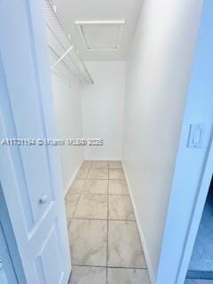 walk in closet with light tile patterned floors