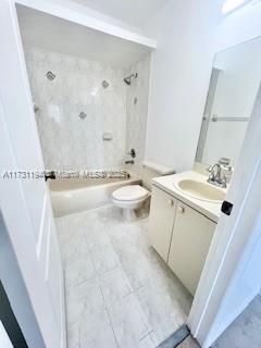 full bathroom featuring vanity, toilet, and tiled shower / bath combo