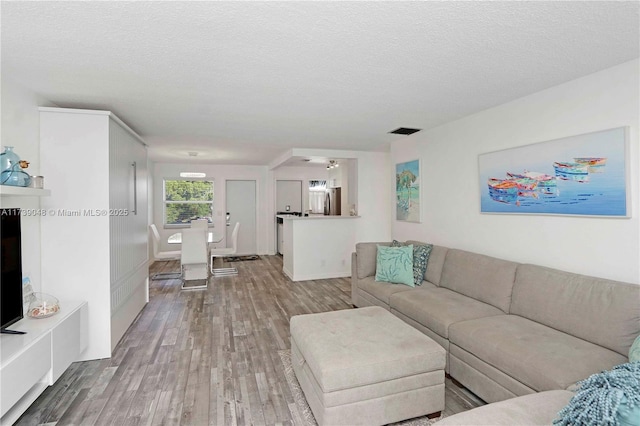 living room with wood-type flooring and a textured ceiling