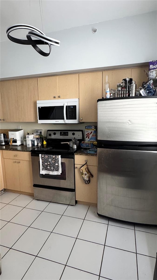 kitchen featuring appliances with stainless steel finishes, light tile patterned floors, and light brown cabinets