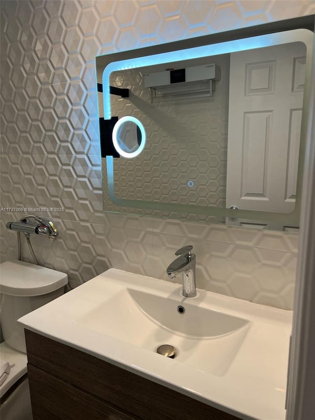 bathroom featuring vanity, decorative backsplash, tile walls, and toilet