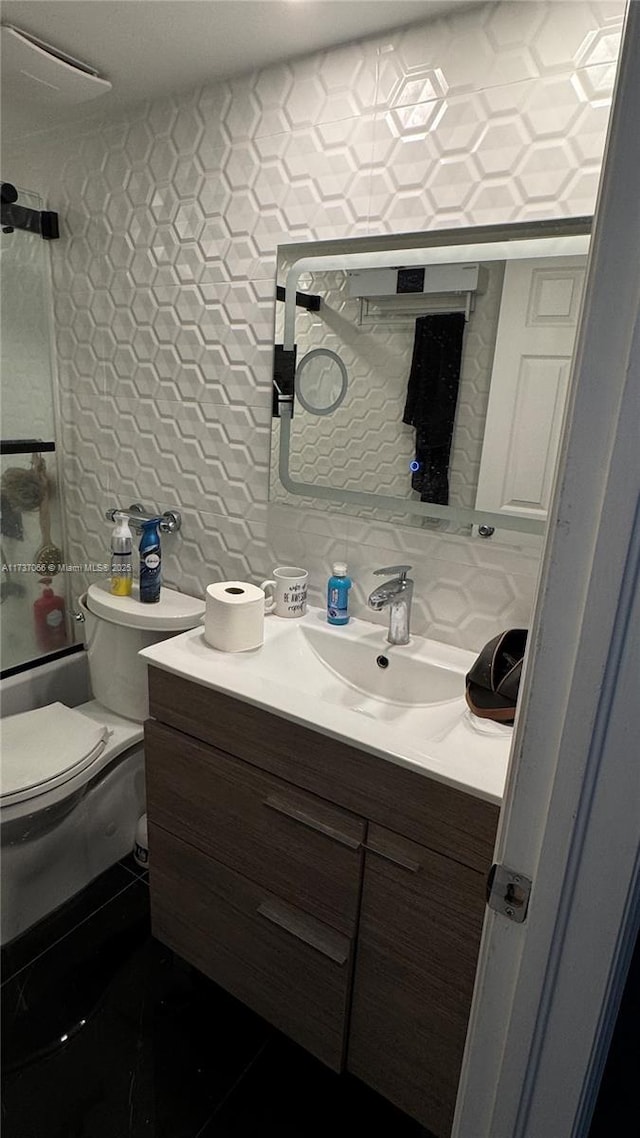 full bathroom featuring enclosed tub / shower combo, tile walls, backsplash, vanity, and toilet