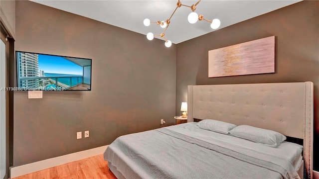 bedroom featuring hardwood / wood-style floors and a notable chandelier