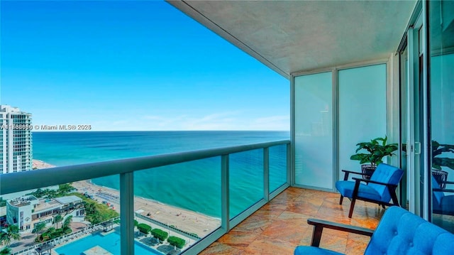 balcony with a water view and a beach view