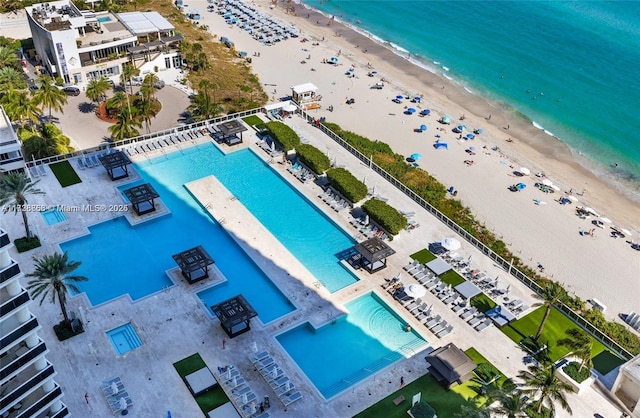 birds eye view of property with a water view and a beach view