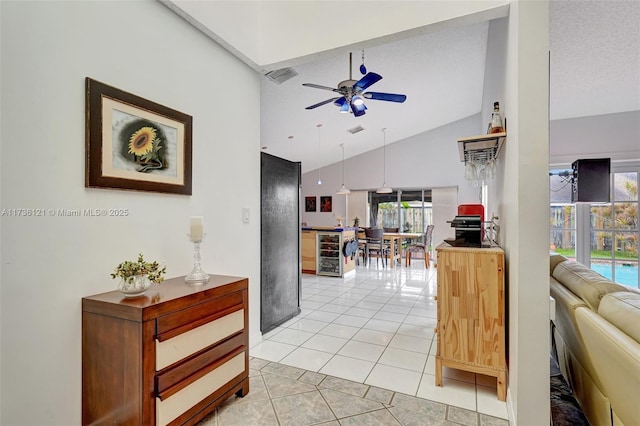 tiled living room featuring ceiling fan, beverage cooler, high vaulted ceiling, and a textured ceiling