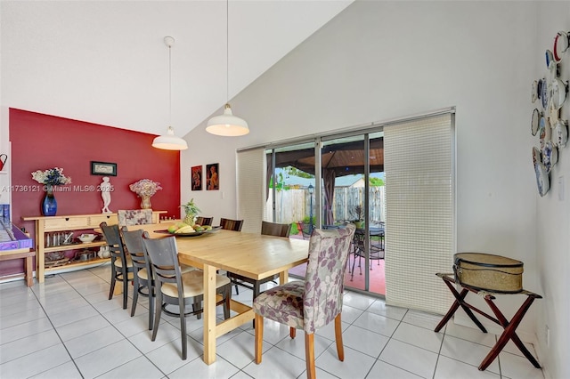 dining area featuring light tile patterned floors and high vaulted ceiling