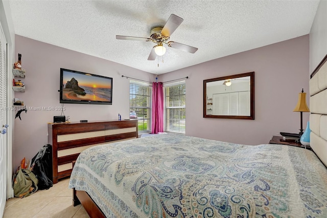 tiled bedroom featuring ceiling fan and a textured ceiling