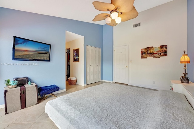 bedroom featuring high vaulted ceiling, a closet, ceiling fan, and light tile patterned flooring