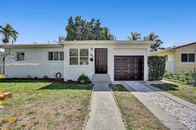 view of front of property with a garage and a front lawn