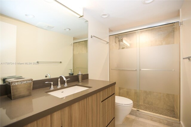 bathroom with vanity, tile patterned flooring, toilet, and walk in shower