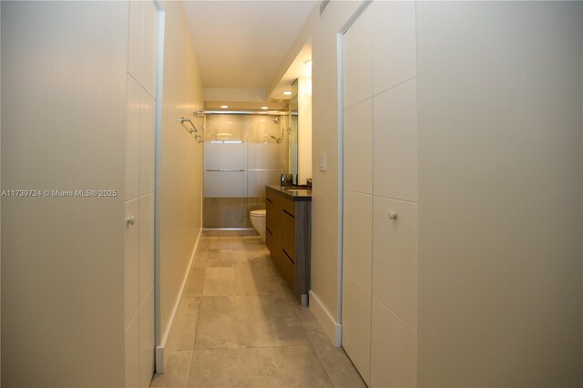 corridor featuring light tile patterned flooring and sink