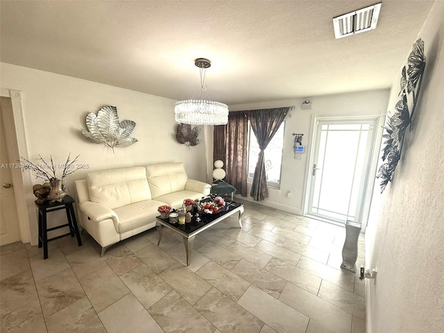 living room featuring a notable chandelier and a textured ceiling