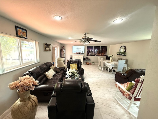 living room with ceiling fan and a textured ceiling