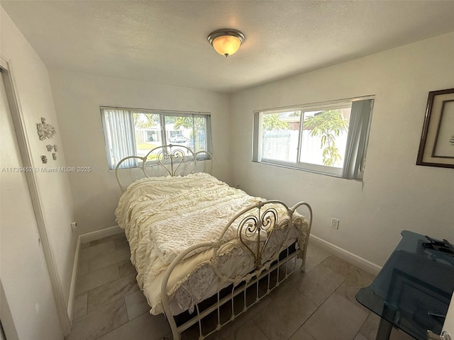 bedroom featuring dark tile patterned flooring and a textured ceiling