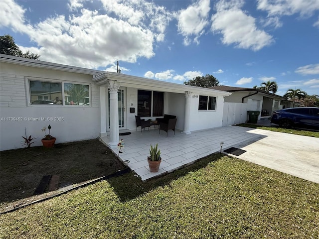 back of property with a yard and a patio