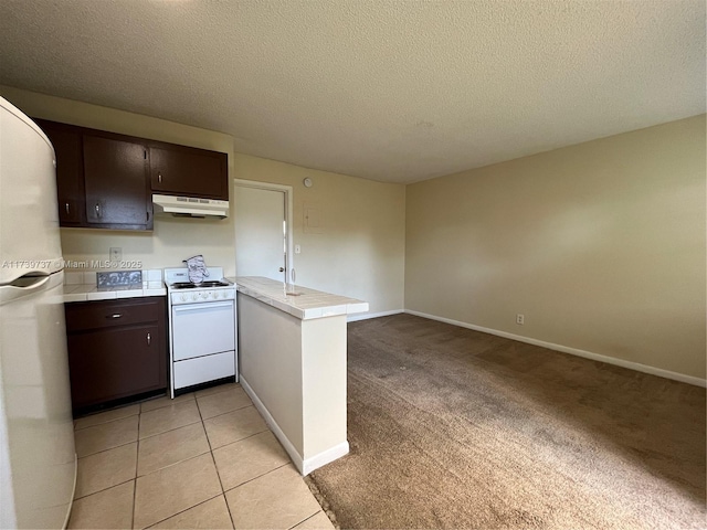 kitchen featuring dark brown cabinetry, light colored carpet, a textured ceiling, kitchen peninsula, and white appliances