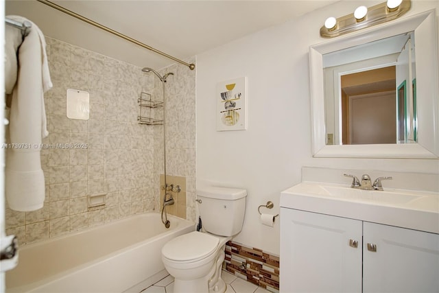 full bathroom featuring tiled shower / bath, vanity, toilet, and tile patterned floors