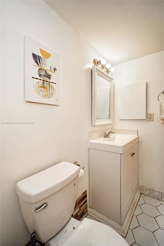 bathroom with vanity, toilet, and tile patterned flooring