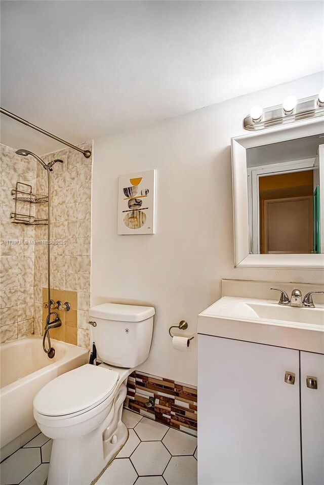 full bathroom with vanity, tiled shower / bath, tile patterned floors, and toilet