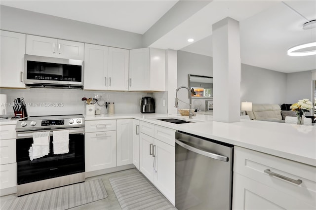 kitchen with appliances with stainless steel finishes, sink, and white cabinets