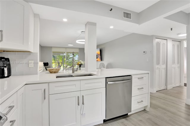 kitchen with backsplash, stainless steel dishwasher, and white cabinets