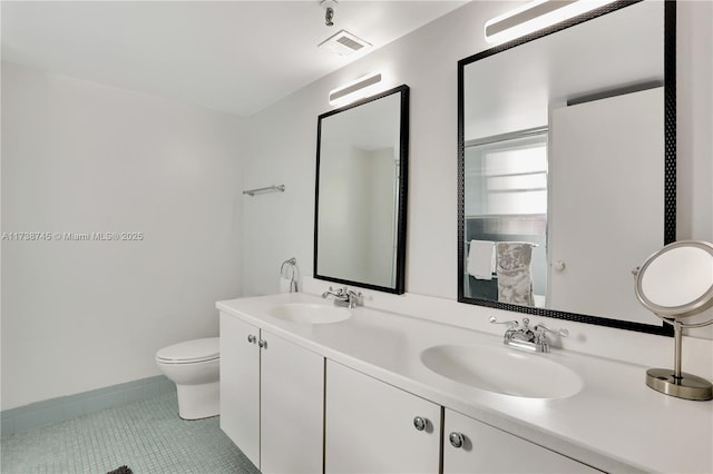 bathroom featuring tile patterned flooring, vanity, and toilet