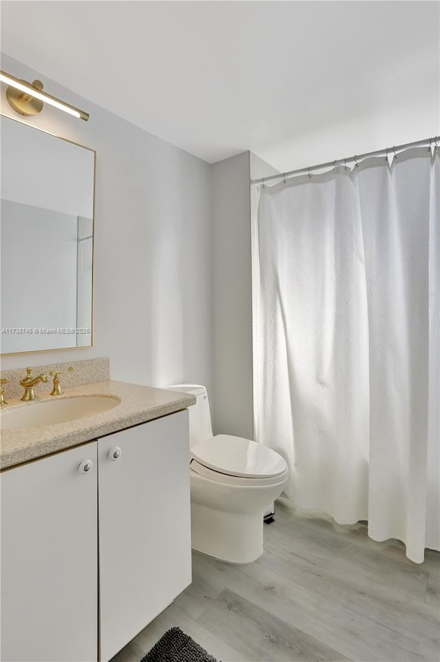 bathroom with vanity, hardwood / wood-style floors, and toilet