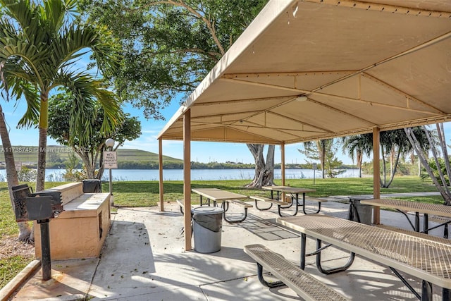 view of home's community with a water view and a lawn