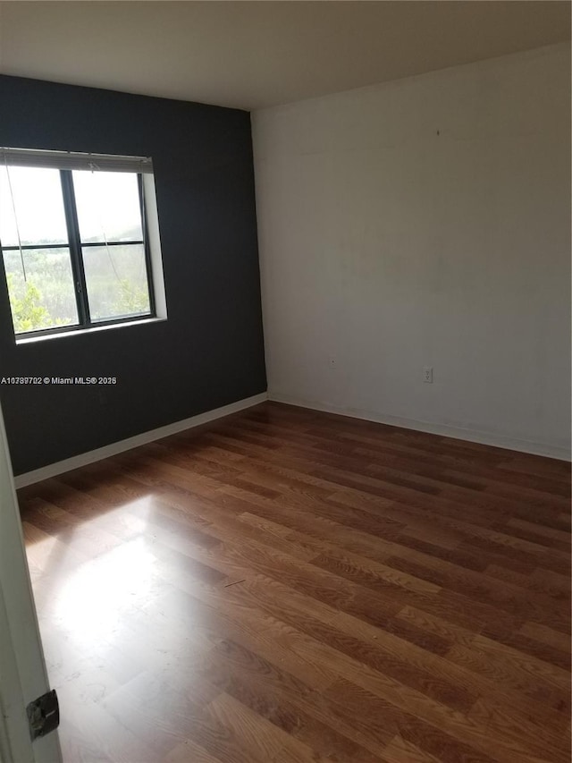 unfurnished room featuring dark wood-type flooring