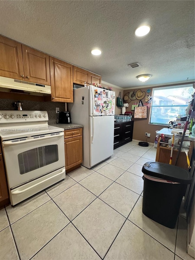 kitchen featuring light tile patterned floors, a textured ceiling, and white appliances