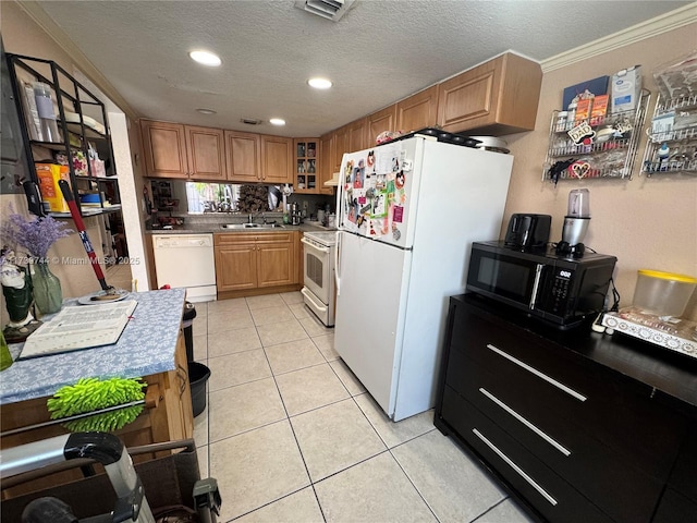 kitchen featuring light tile patterned floors, crown molding, white appliances, sink, and a textured ceiling