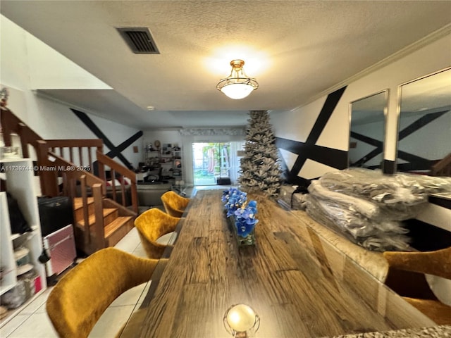 dining area with crown molding, hardwood / wood-style floors, and a textured ceiling