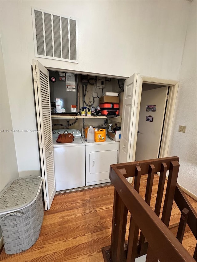 washroom with separate washer and dryer and hardwood / wood-style floors