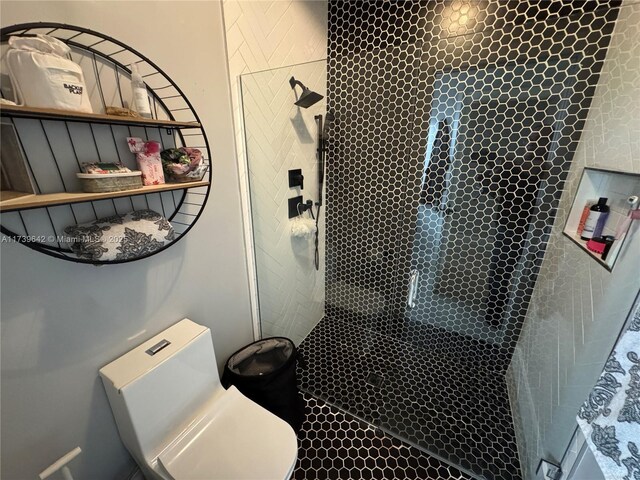 bathroom featuring toilet and a shower with door