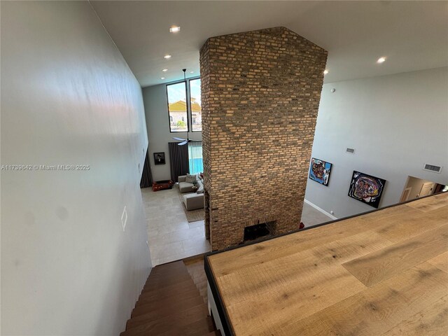 hall with lofted ceiling and brick wall