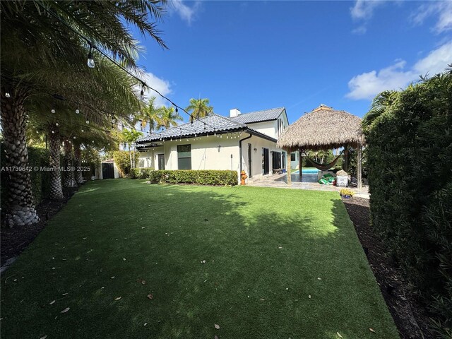 rear view of house with a gazebo and a lawn